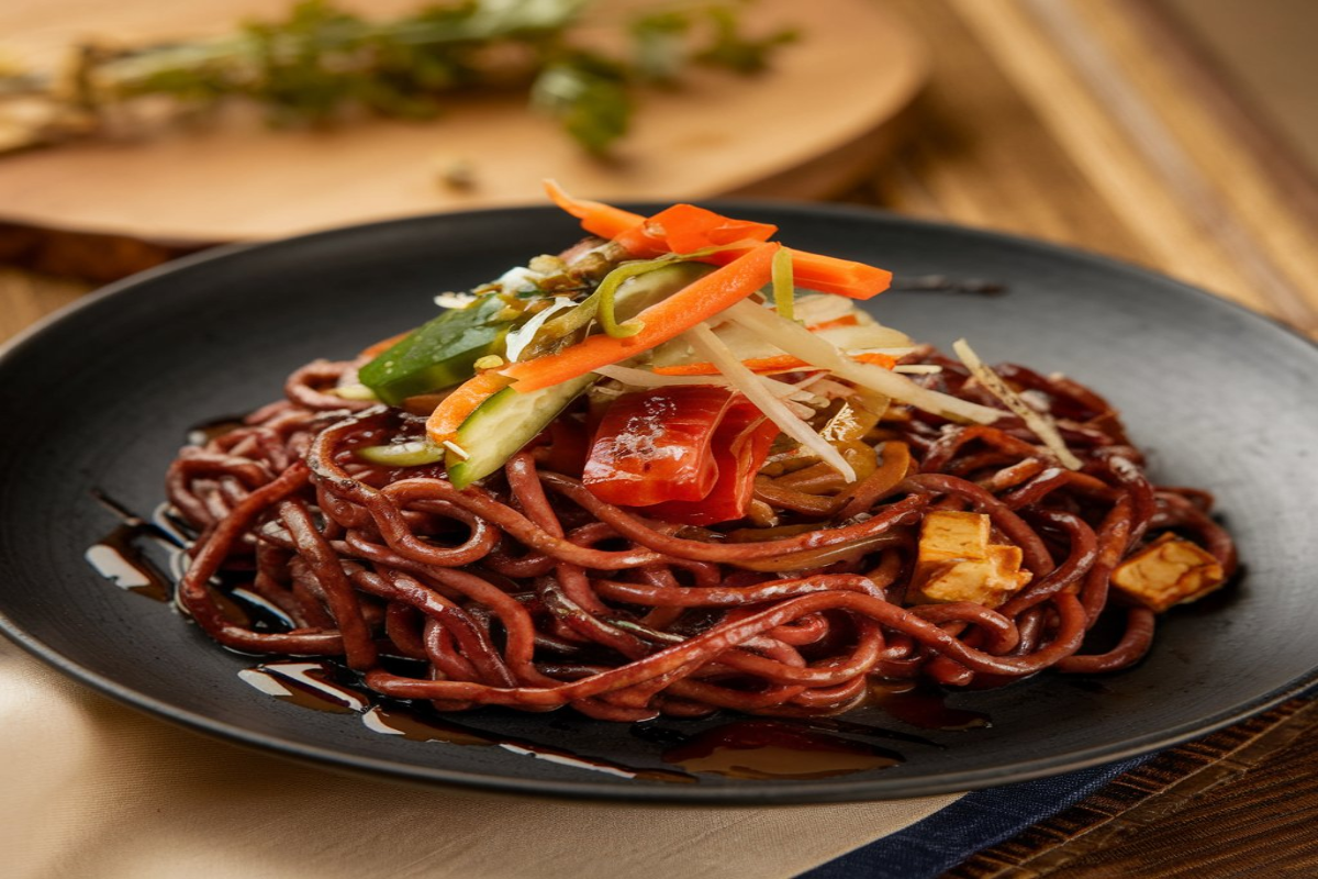 Black Bean Noodles served in a bowl with vegetables and sauce